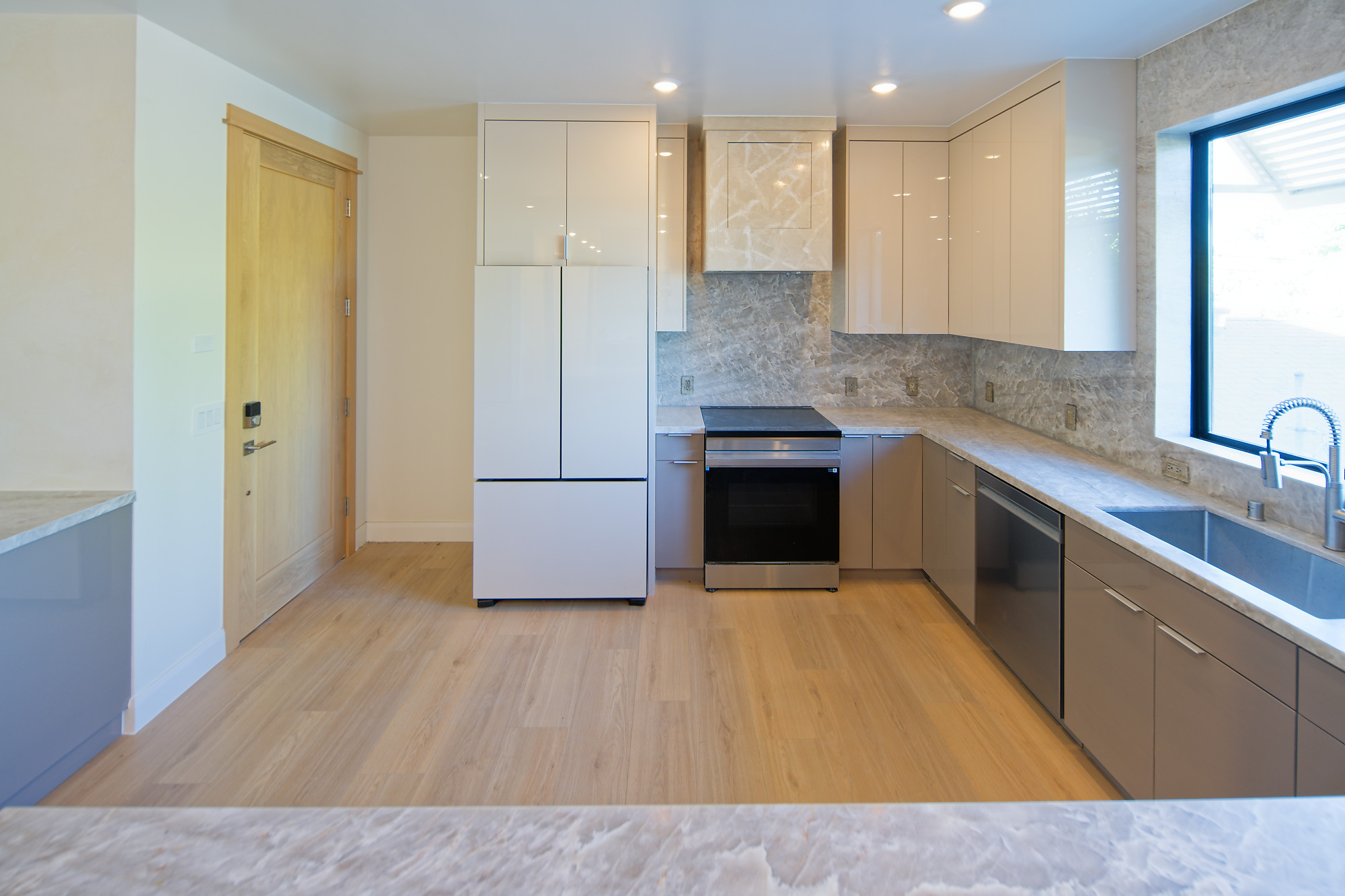 Completed project — 10: Kitchen with white upper cabinets, gray lower cabinets, and stone backsplash